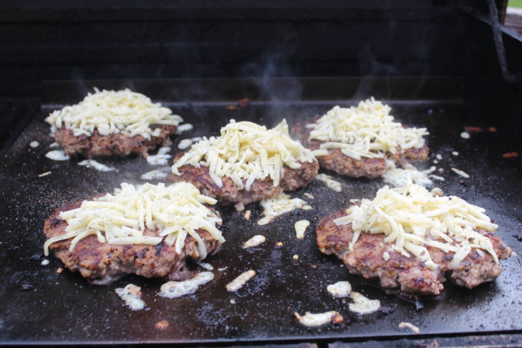 burger on grill with cheese
