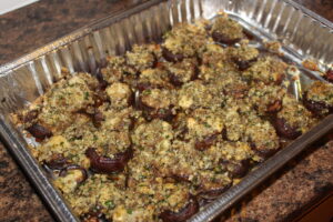 Finished cooked gorgonzola stuffed balsamic mushrooms in aluminum pan
