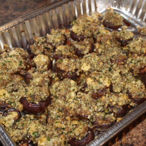 Finished cooked gorgonzola stuffed balsamic mushrooms in aluminum pan