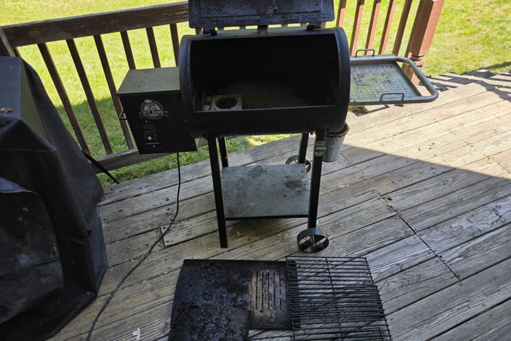 Pit Boss pellet grill opened up with grates and flame broiler removed for cleaning