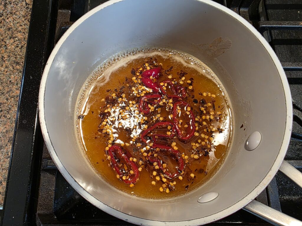 Hot honey warming on the stove with bubbles around the edges of the pan