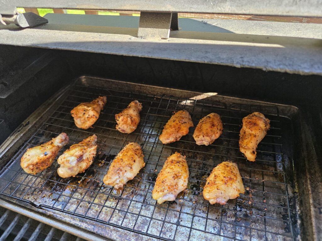 Seasoned chicken wings on a rack in a Pit Boss pellet smoker