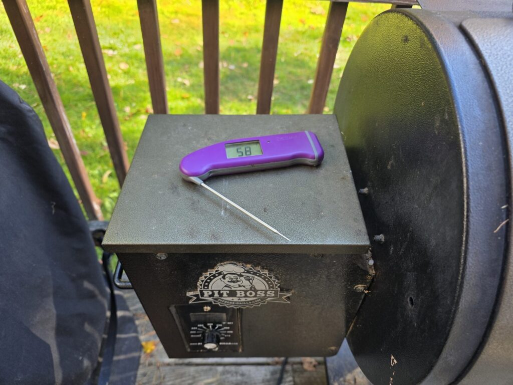 ThermoWorks Thermapen ONE instant-read thermometer sitting on a Pit Boss pellet grill hopper